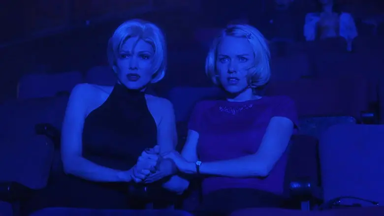 Betty and Rita sit together in the blue light of Club Silencio