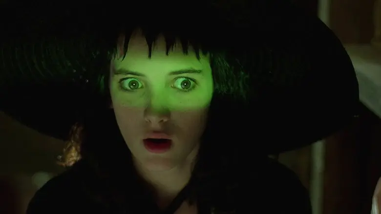 A woman staring forward under a vivid green band of light