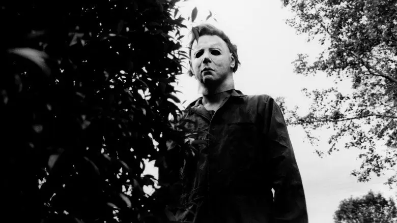 A masked figure standing among trees in Halloween
