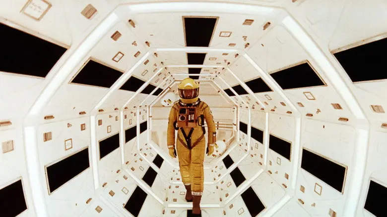 An astronaut in an orange spacesuit walking through a white geometric corridor in 2001: A Space Odyssey