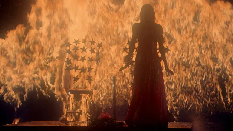 Carrie standing before a wall of fire