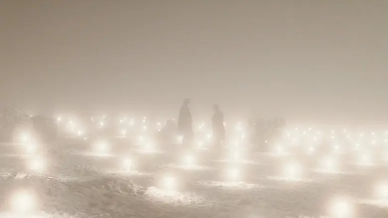 Two distant figures standing among bright lights in a snowy field in The Prestige