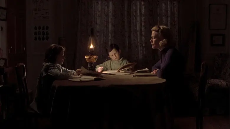 A family gathered around a candle in The Others