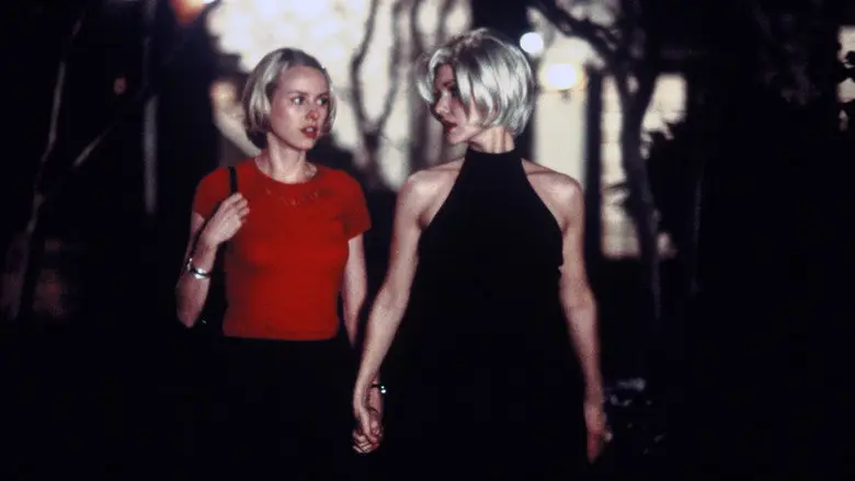Betty and Rita walk together at night in Mulholland Drive