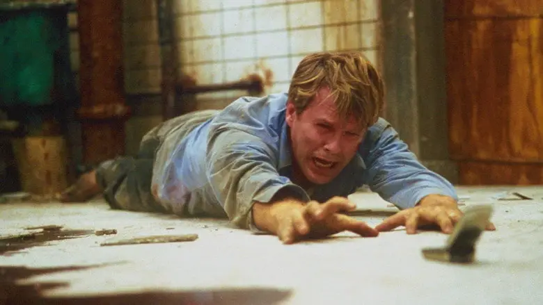 A man crawling across the bathroom floor in Saw