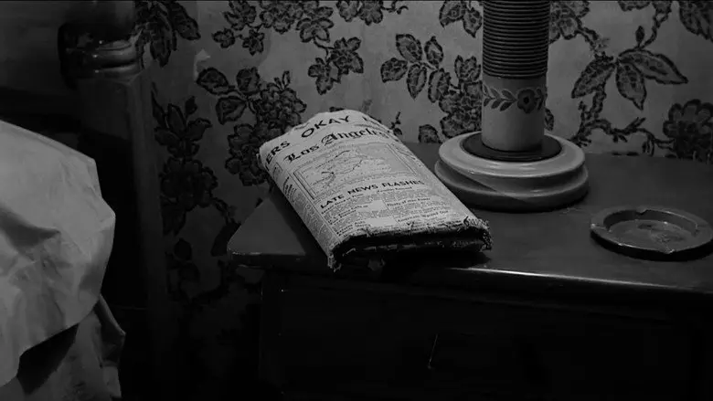 A folded newspaper on a bedside table beside a lamp in Psycho