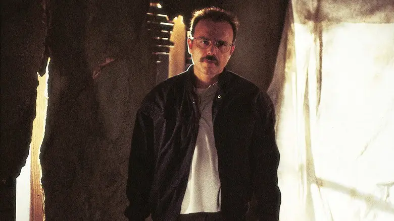 A man standing in a damaged room in Memento