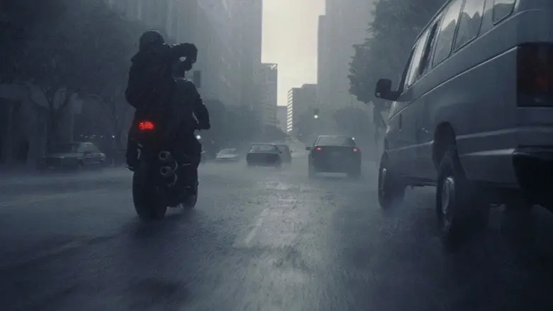 A motorcycle moving through wet city traffic in Inception