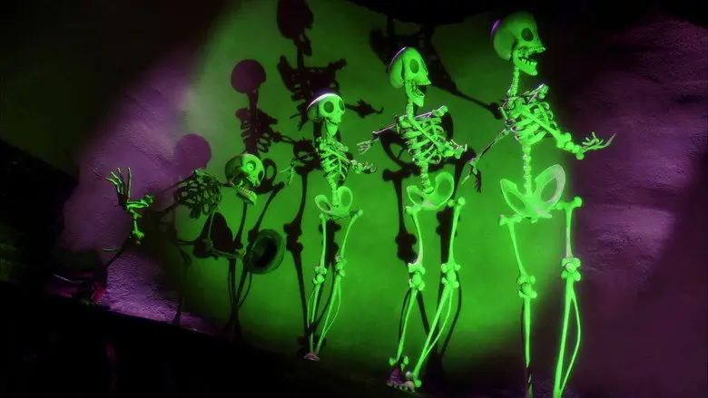 A row of glowing skeletons performing together under green and purple light