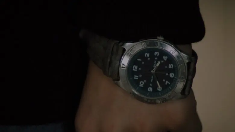 A watch held against a dark sleeve in The Sixth Sense